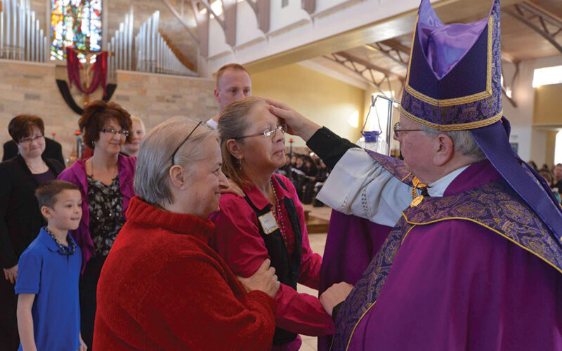 Bishop prays over RCIA catechumen